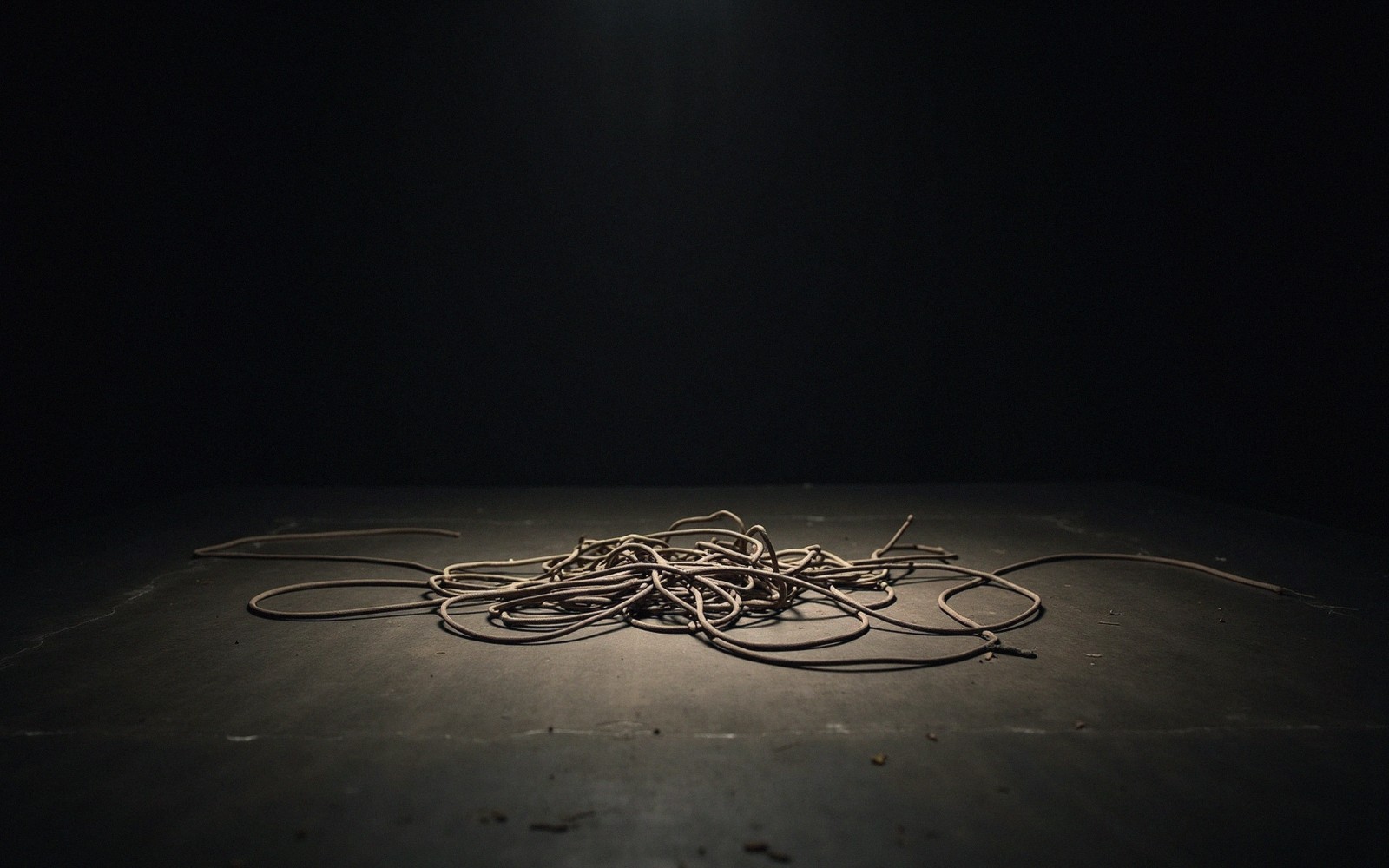Tangle of cable on a stage floor under harsh flash light